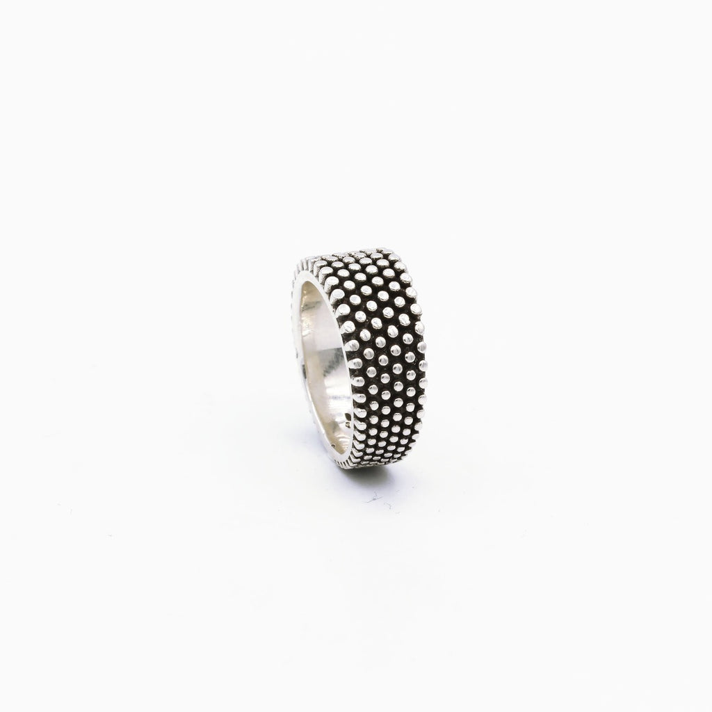 A sterling silver ring with a finely dotted pattern on the band, displayed against a white background.
